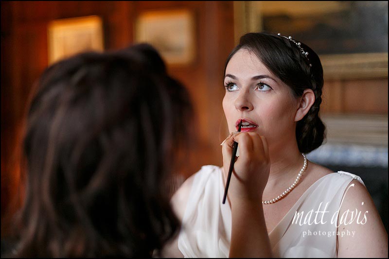 Bride with dark hair and bright red lipstick styled for winter wedding at Elmore Court