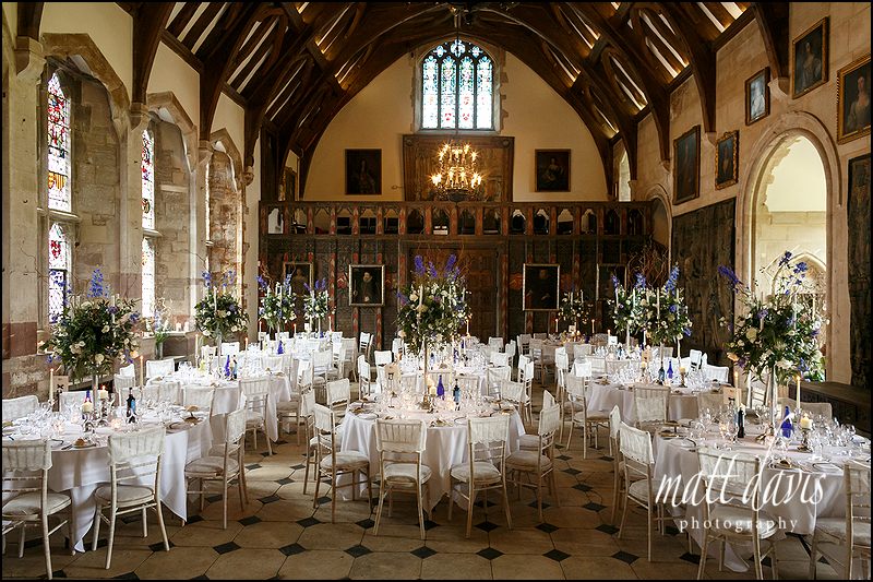 The great hall at Berkeley Castle packed with candle arbors and wedding flowers